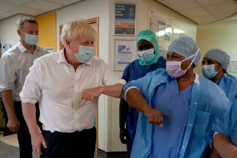 PA Media Then-Prime Minister Boris Johnson meets members of staff during a visit to the South West London Elective Orthopaedic Centre in Epsom on 26 August 2022