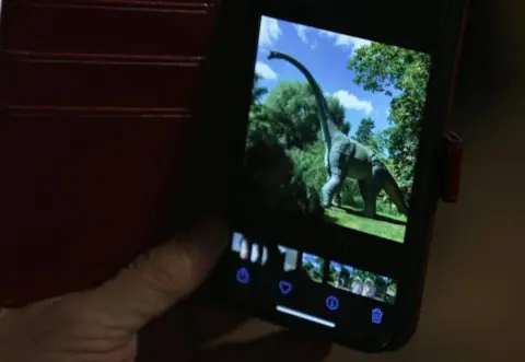 Tim Burton shows the BBC a picture of one of his dinosaur models 