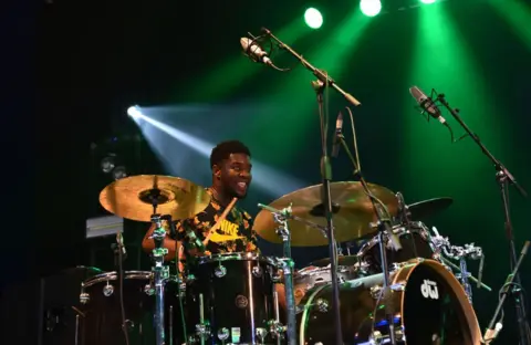 Getty Images Femi Koleoso of Ezra Collective plays drums live on stage at the 2018 Womad Festival